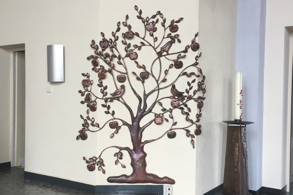Taufbaum aus Metall als Wandschmuck.